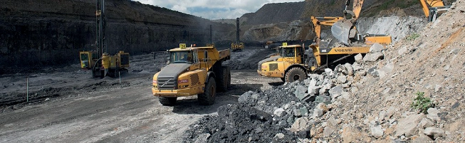 Heavy machinery working in open air mine.
